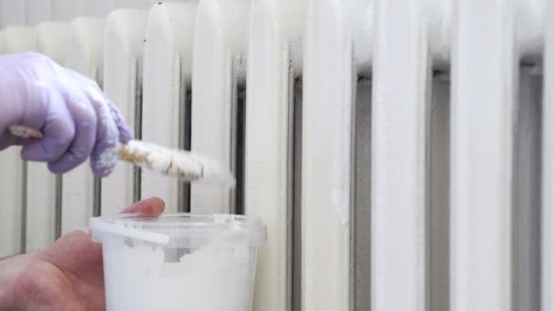 Painter arm in glove painting heating radiator — Stock Video