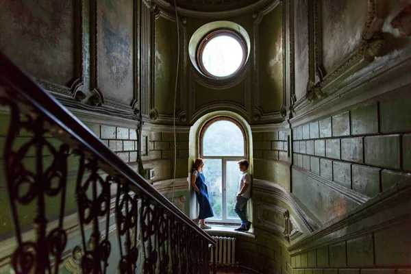 Pareja se encuentra en el alféizar de la ventana grande en la casa vieja — Foto de Stock