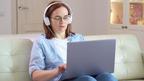 Woman completed works at computer with headphones — Stock Video