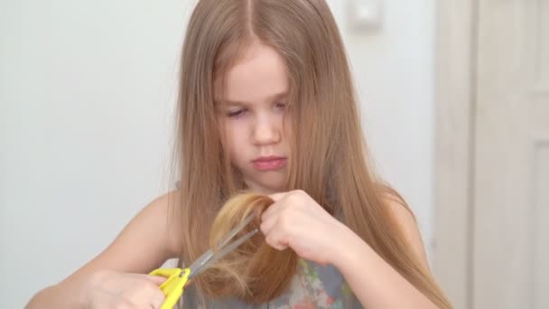 Mała dziewczynka cięcia włosy do siebie nożyczkami — Wideo stockowe