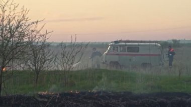 Gökyüzü dumanında kuru ot yakar. İtfaiyeciler çalışıyor