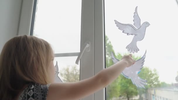 Kind setzt Taubenfenster als Symbol für den Frieden auf — Stockvideo