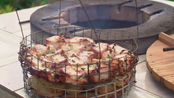Человек готовит мясо и картофель внутри печи тандира — стоковое видео