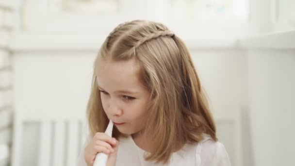 Grappig meisje reinigt tanden elektrische tandenborstel — Stockvideo
