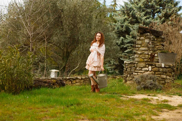 Chica con regadera en el jardín en casa de campo — Foto de Stock
