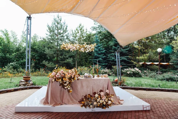 Table of bride and groom in tent in the open air. — Stock Photo, Image