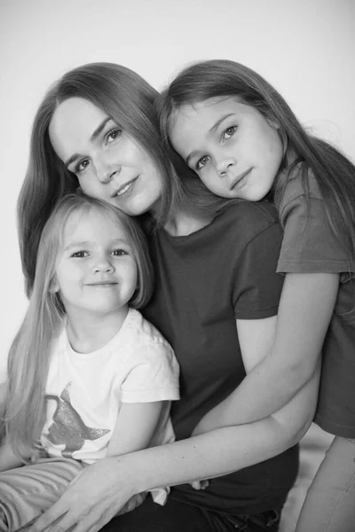 Ibu dan dua anak perempuan masing-masing memeluk. hitam-putih . — Stok Foto