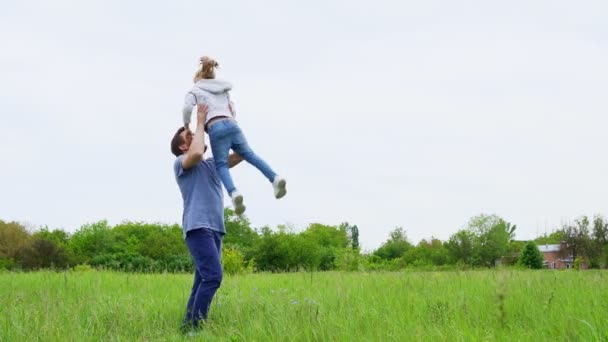 Far och dotter gå runt och spela på fältet — Stockvideo