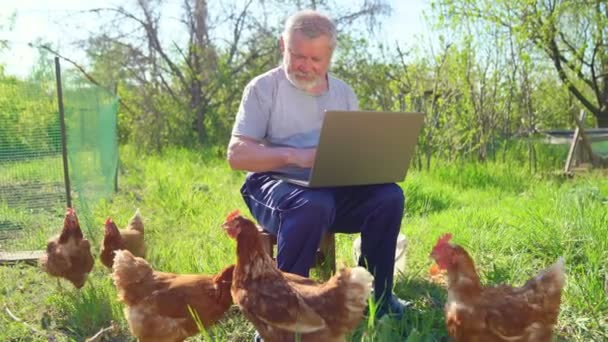 Homem idoso com um laptop na aldeia — Vídeo de Stock
