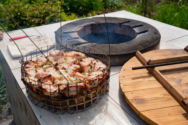 Meat and potatoes cooked inside a tandoor, stone oven in garden. — Stock Photo, Image