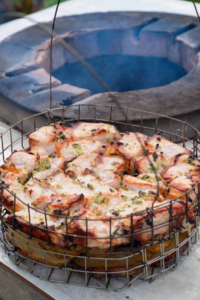 Carne e batatas cozidas dentro de um tandoor, forno de pedra no jardim . — Fotografia de Stock