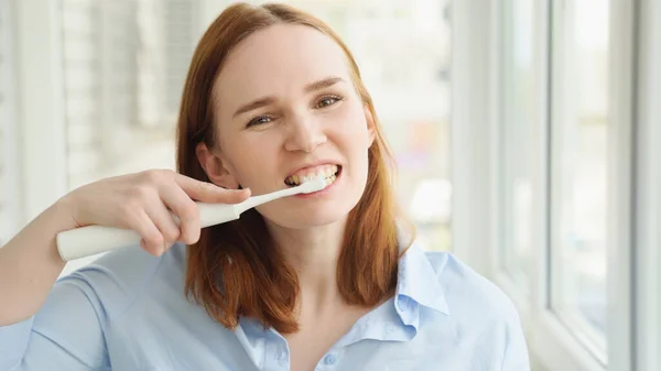 Mujer limpia dientes cepillo de dientes eléctrico — Foto de Stock