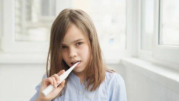 Nastolatek dziewczyna czyści zęby elektryczne szczoteczka do zębów — Zdjęcie stockowe