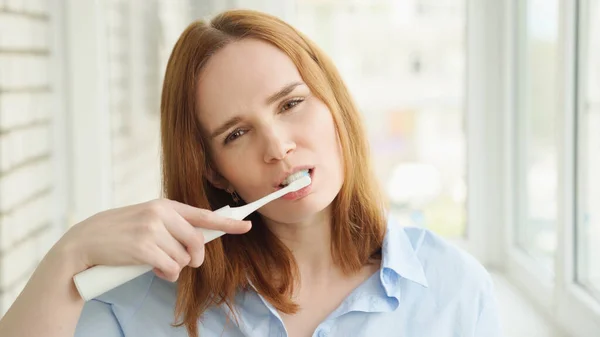 Mujer limpia dientes cepillo de dientes eléctrico — Foto de Stock