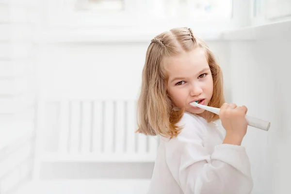 funny girl cleans teeth electric toothbrush