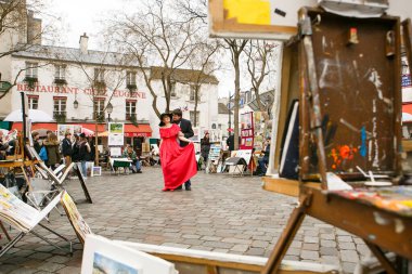 Montmartre 'de sokak sanatçıları arasında sevgi dolu bir çift. Turizm merkezi.