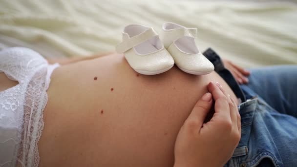 Terhes lányok hasa, gyerekcipők. A baba rúgott a méhbe.. — Stock videók