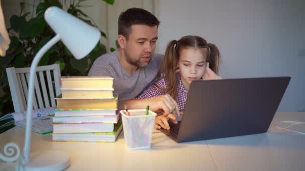 Pai ajuda a filha com aulas on-line no laptop. educação à distância . — Vídeo de Stock