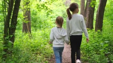 Ormanda birlikte yürüyen küçük kızlar. arka plan.