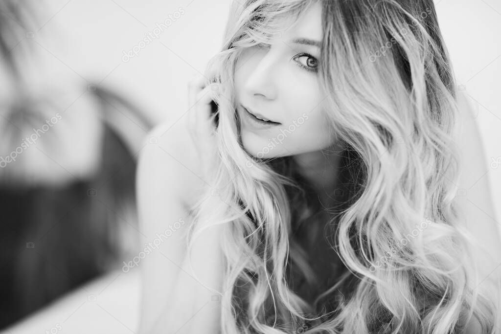 portrait of sexy beautiful girl with long blond hair in bed