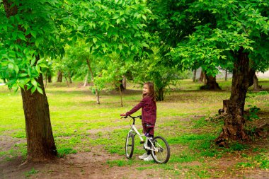 Bisikletli kız bahar parkında. 