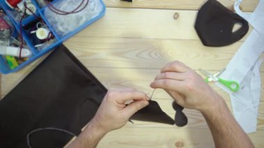 Erkek elleri siyah bir maske ile dikilir.