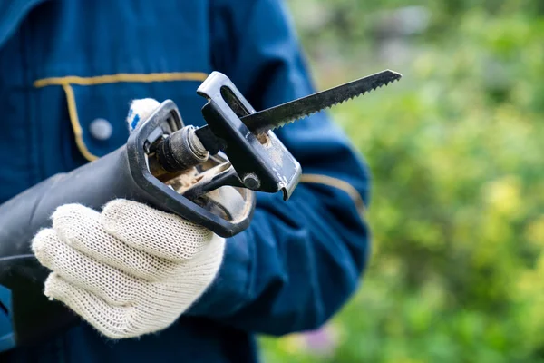 Männliche Hand mit einer Säbelsäge. Bauarbeiten. — Stockfoto