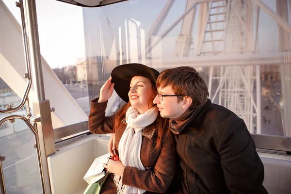 Pareja hombre y mujer cabalgando en la cabina en la rueda de la fortuna en París . — Foto de Stock