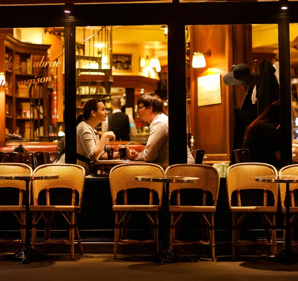 Pareja de hombres y mujeres sentados por las noches. una cena romántica en París . — Foto de Stock