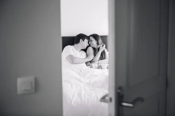 Пара любовников в спальне. вид через дверной проем. черный и белый . — стоковое фото