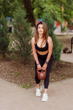 Kız sporcu Park 'ta ağırlık ve kardiyo egzersizleri yapıyor.