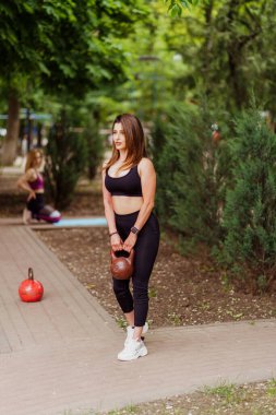 Kız sporcu Park 'ta ağırlık ve kardiyo egzersizleri yapıyor.