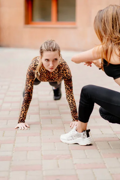 girls athletes in sports apparel, working with a trainer, is a bar in Park.