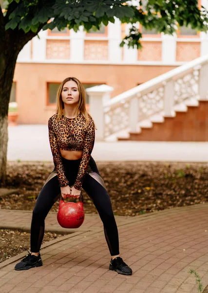Dívka sportovec dělá silová cvičení s váhou, kardio cvičení v parku — Stock fotografie