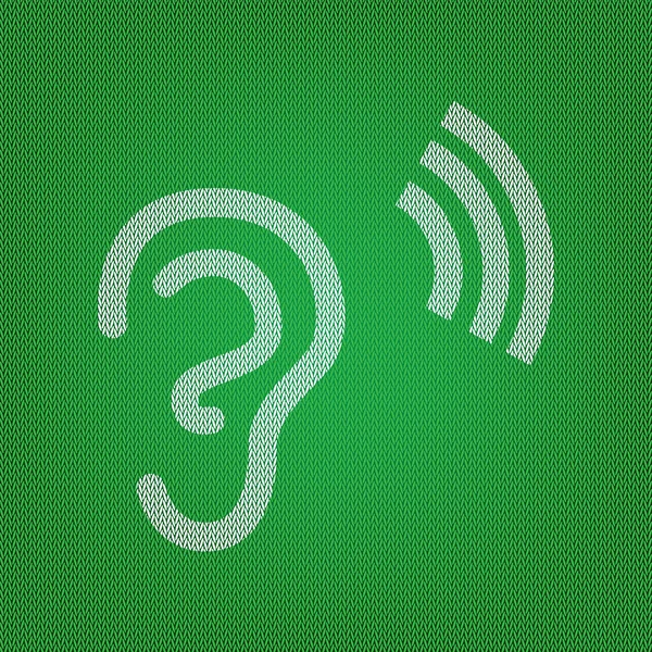Segno dell'orecchio umano. icona bianca sulla maglieria verde o sul panno di lana — Vettoriale Stock