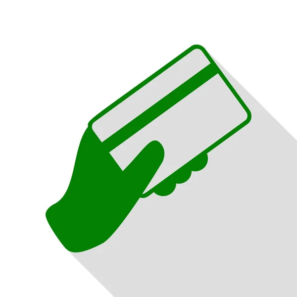 Hand hält eine Kreditkarte. grünes Symbol mit flachem Schattenpfad. — Stockvektor