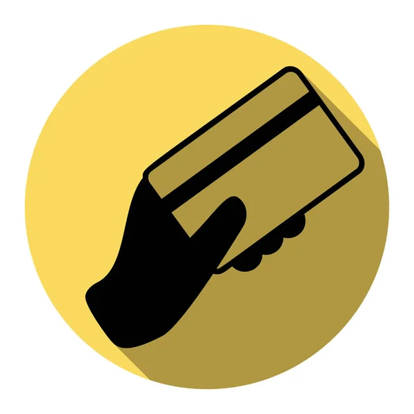 Χέρι που κρατά μια πιστωτική κάρτα. Διάνυσμα. Επίπεδη μαύρο εικονίδιο με επίπεδη σκιά στο Βασιλικό κίτρινο κύκλο με λευκό φόντο. Απομονωμένη. — Διανυσματικό Αρχείο