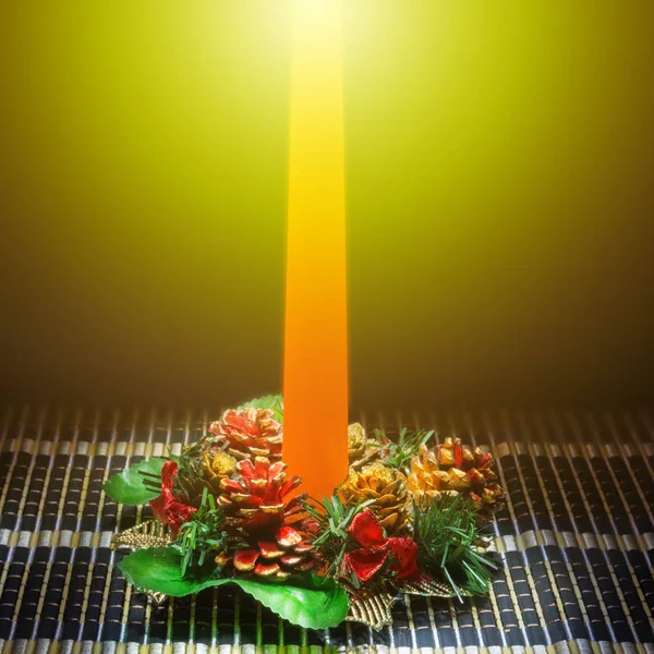 Karanlık bir arka plan üzerinde Noel dekorasyonu ile masaya mum turuncu.