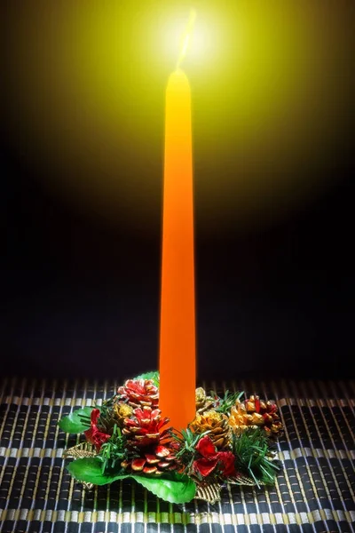 Karanlık bir arka plan üzerinde Noel dekorasyonu ile masaya mum turuncu.