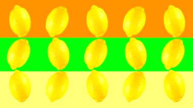 Renkli arka planda birkaç sarı limonun dönüşünün animasyonu. 15 meyvenin farklı yönlerde döndüğü video döngüsü.