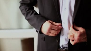 Genç gelin elbise ve gömlek düğmeleri. Mutlu genç damat onların düğün günü. Adam bir pencerenin önünde tişörtünü kadar düğmelerini. Düğün kavramı.
