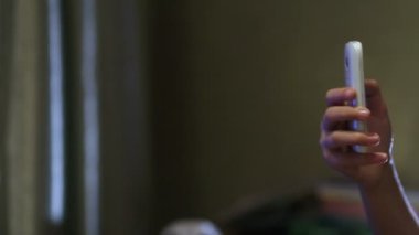 Atış genç çocuğun akıllı telefonda oynamak kapatın. Çocuklar başparmak ekranın swiping. Parmak ve başparmak ile alan sığ derinliği