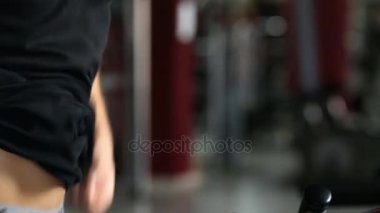 Egzersiz ve spor salonunda koşu bandı üzerinde çalışan genç atletik erkek.