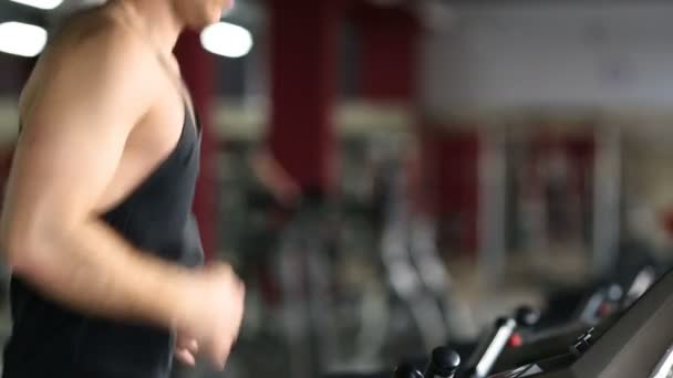 Junge athletische Männer beim Training und Laufen auf dem Laufband in der Sporthalle. — Stockvideo