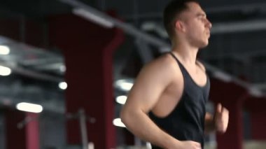 İnsanlar spor salonunda koşu bandında koşuyor.