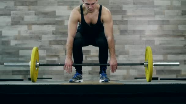 Medium shot slow mo tilt-down tilt-up Männer beim Training und Heben von Gewichten weibliche Bodybuilderin Meisterin bei der sauberen Leistung in Crossfit-Turnhalle — Stockvideo