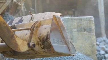 Ekskavatör ezilmiş taş ormanın üzerine yayılmış