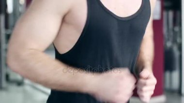 Egzersiz ve spor salonunda koşu bandı üzerinde çalışan kadın ve genç atletik erkek. 4 k'dan fazla vurdu