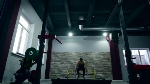 Medium skott långsamma mo tilt-down tilt-up män utövar och lyfta vikter kvinnlig kroppsbyggare världsmästare idrottsman gör power clean i cross fit gym — Stockvideo