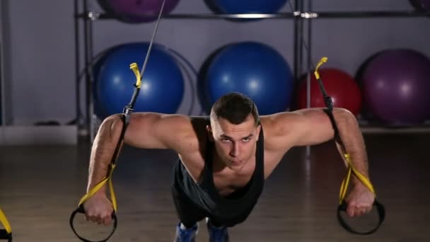 Hombre haciendo ejercicio en Trx en un gimnasio — Vídeos de Stock